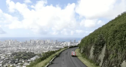 a road with a car on it and a city in the background